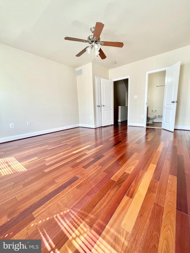 empty room featuring wood finished floors, ceiling fan, and baseboards