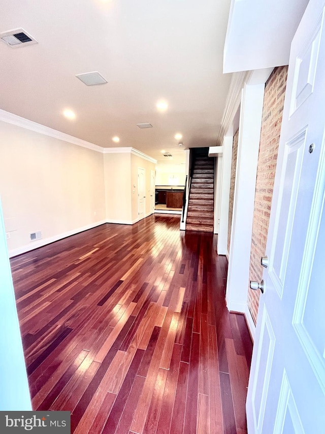 below grade area featuring stairway, crown molding, dark wood finished floors, baseboards, and recessed lighting
