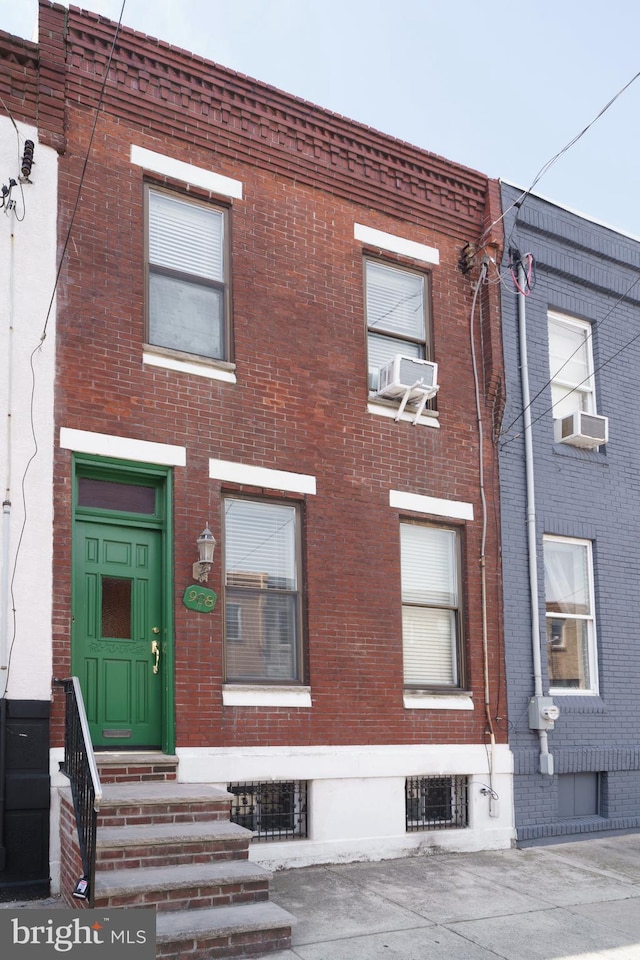 view of front facade featuring brick siding, entry steps, and cooling unit