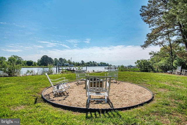 view of green lawn featuring a water view