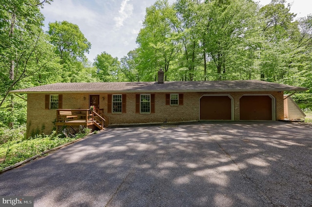 659 Lancaster Pike, New Providence, PA 17560 - ranch-style home with asphalt driveway, a garage, brick siding, a chimney, and covered porch