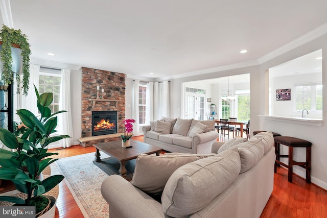 13626 Sylvan Bluff Dr, Leesburg, VA 20176 - living area featuring healthy amount of natural light, ornamental molding, wood-type flooring, a fireplace, and a chandelier