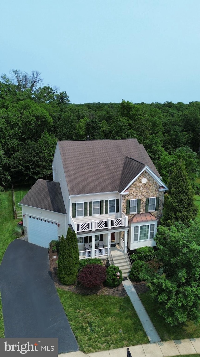 13626 Sylvan Bluff Dr, Leesburg, VA 20176 - view of front of house with covered porch, a garage, a forest view, asphalt driveway, and roof with shingles
