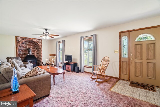 13245 Croom Rd, Upper Marlboro, MD 20772 - living area featuring a wood stove, carpet, a ceiling fan, and baseboards