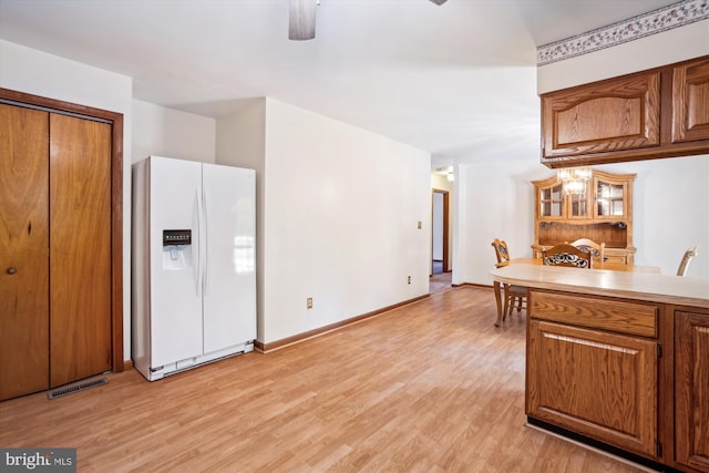 13245 Croom Rd, Upper Marlboro, MD 20772 - kitchen featuring white refrigerator with ice dispenser, brown cabinets, light wood finished floors, and light countertops