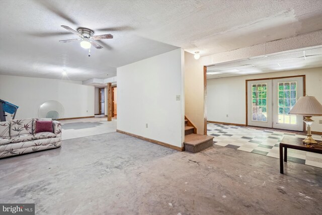 13245 Croom Rd, Upper Marlboro, MD 20772 - unfurnished living room featuring stairway, unfinished concrete flooring, baseboards, a ceiling fan, and a textured ceiling