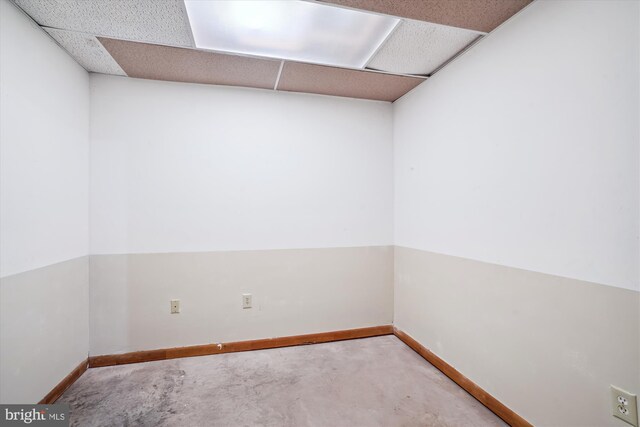 13245 Croom Rd, Upper Marlboro, MD 20772 - empty room with unfinished concrete floors, baseboards, and a paneled ceiling