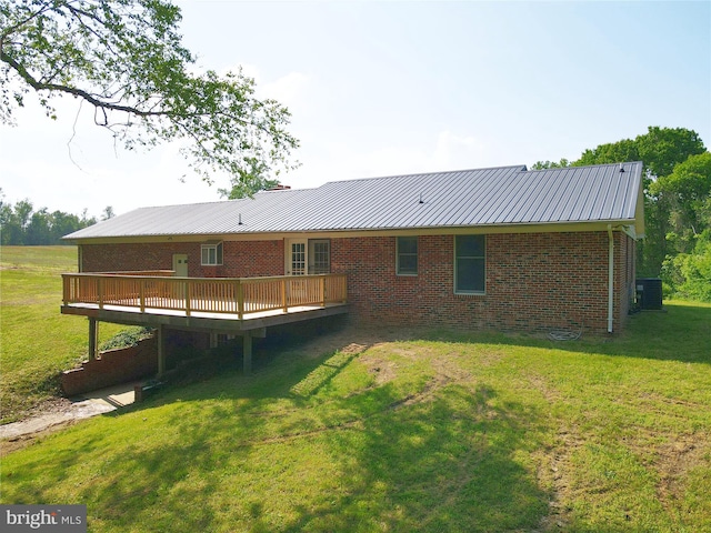 13245 Croom Rd, Upper Marlboro, MD 20772 - rear view of house featuring a wooden deck, metal roof, a yard, brick siding, and central AC unit