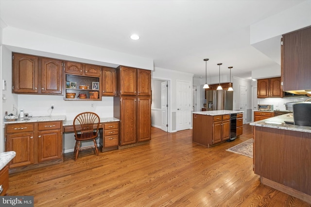 kitchen featuring stainless steel fridge, light wood-type flooring, decorative light fixtures, a center island, and recessed lighting