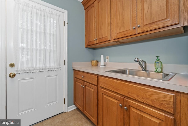 laundry area with a sink and light tile patterned flooring