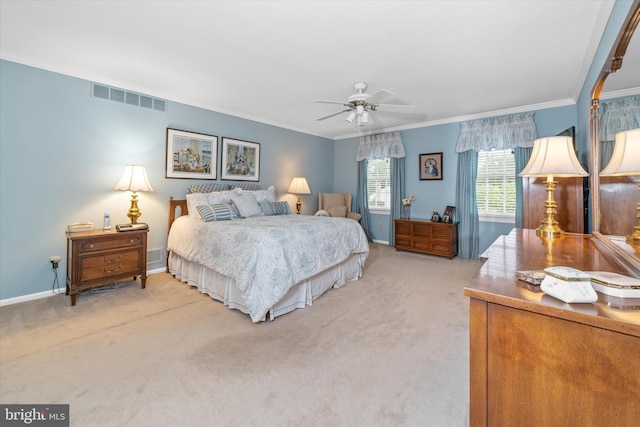 bedroom featuring light colored carpet, ornamental molding, baseboards, and a ceiling fan