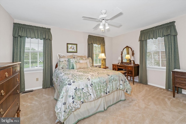 bedroom featuring light carpet, baseboards, and a ceiling fan