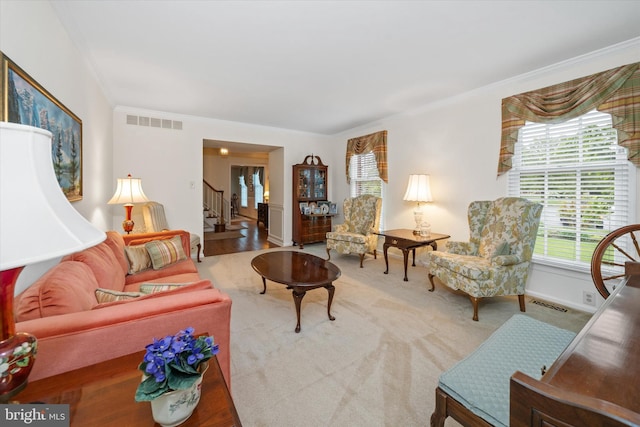 carpeted living room featuring ornamental molding, stairs, and baseboards