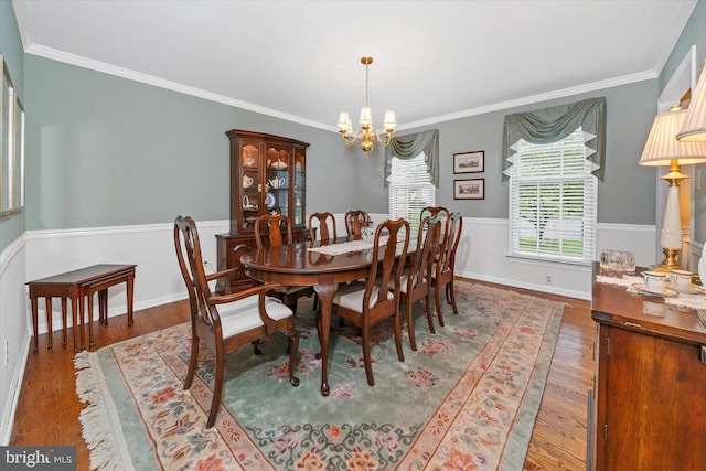 dining space featuring a chandelier, wood finished floors, and ornamental molding