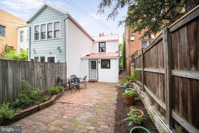 525 6th St SE, Washington, DC 20003 - rear view of property with a patio, a fenced backyard, metal roof, outdoor dining area, and a standing seam roof