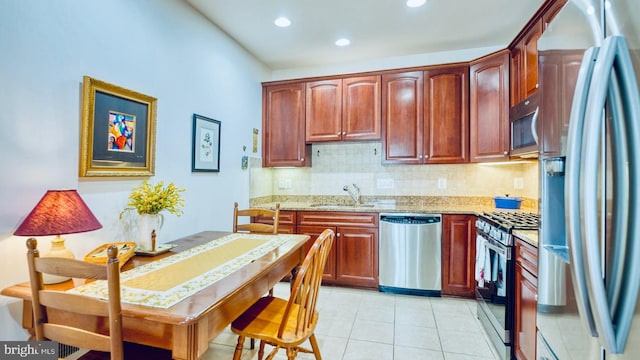 44458 Maltese Falcon Sq, Ashburn, VA 20147 - kitchen featuring appliances with stainless steel finishes, a sink, backsplash, light tile patterned flooring, and light stone countertops