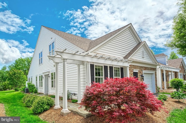 44458 Maltese Falcon Sq, Ashburn, VA 20147 - view of home's exterior with a garage, a shingled roof, a pergola, central AC, and a lawn
