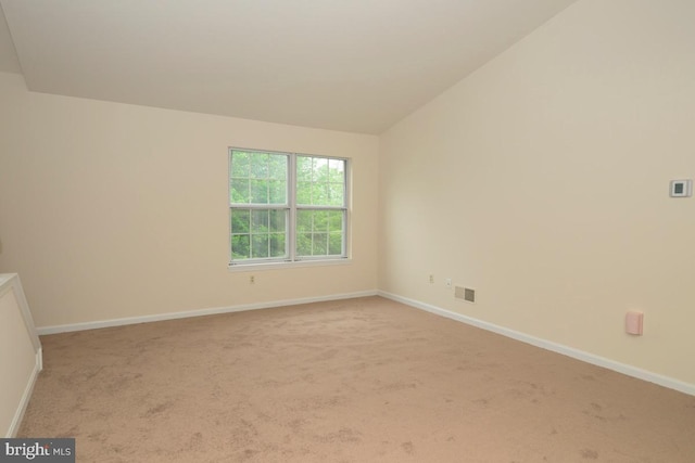 carpeted empty room with baseboards and lofted ceiling
