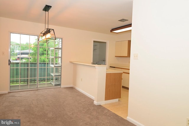 unfurnished dining area with light colored carpet and baseboards