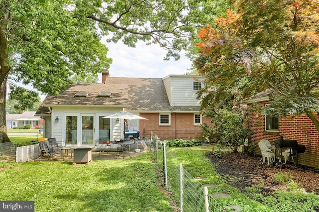 621 E Walnut St, Palmyra, PA 17078 - rear view of house featuring a chimney, a patio area, a shingled roof, and brick siding