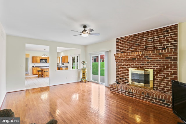 3547 Green Spring Rd, Havre De Grace, MD 21078 - unfurnished living room featuring light wood-type flooring, a ceiling fan, a fireplace, and baseboards