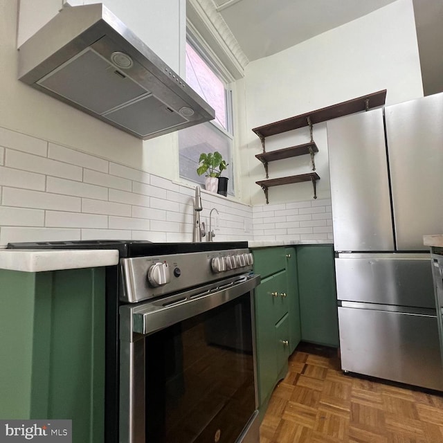 2947 W Girard Ave, Philadelphia, PA 19130 - kitchen with green cabinets, stainless steel appliances, under cabinet range hood, light countertops, and decorative backsplash