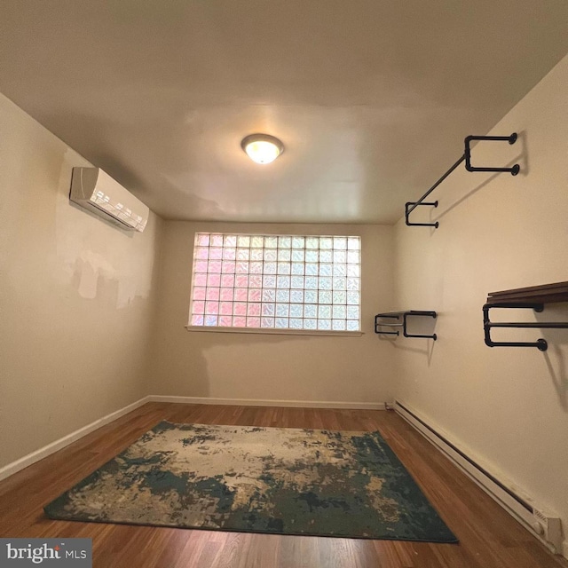 2947 W Girard Ave, Philadelphia, PA 19130 - spare room featuring a wall mounted air conditioner, a baseboard radiator, baseboards, and wood finished floors