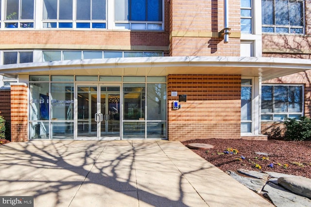 property entrance featuring brick siding and french doors