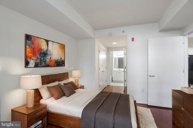 bedroom featuring wood finished floors and ensuite bathroom