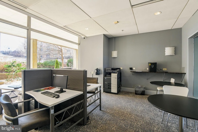 carpeted dining room featuring an office area and baseboards