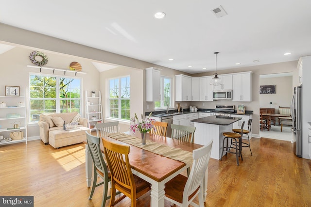 dining space featuring light wood-style flooring, recessed lighting, and baseboards