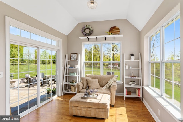 sunroom / solarium featuring healthy amount of natural light, vaulted ceiling, and french doors