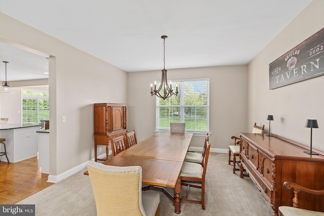 dining space featuring a chandelier and baseboards