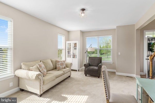 living area with light colored carpet and baseboards