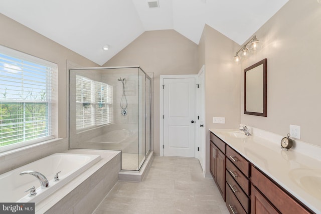 full bathroom with a shower stall, a garden tub, lofted ceiling, double vanity, and plenty of natural light