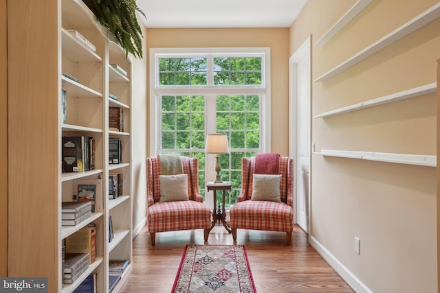 sitting room featuring healthy amount of natural light, baseboards, and wood finished floors
