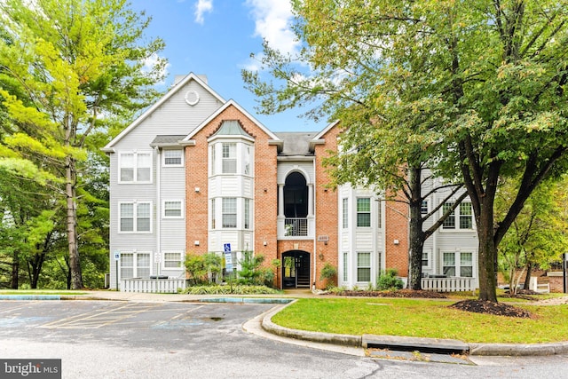 view of front of property featuring brick siding and uncovered parking