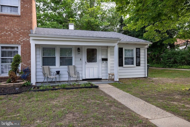 19 Rittenhouse Dr, Willingboro, NJ 08046 - view of front of property featuring covered porch, a chimney, roof with shingles, and a front yard