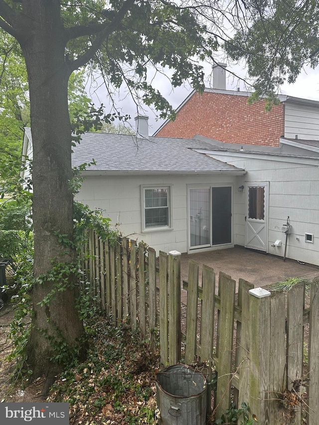 19 Rittenhouse Dr, Willingboro, NJ 08046 - back of house with roof with shingles, fence, and a chimney