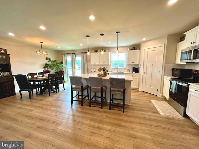 17 Perspective Pl, Hedgesville, WV 25427 - kitchen featuring stainless steel microwave, electric range, a sink, light countertops, and a kitchen island