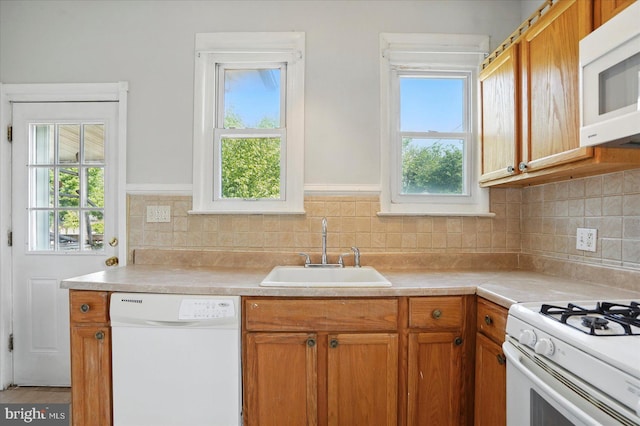 kitchen with white appliances, a sink, and healthy amount of natural light