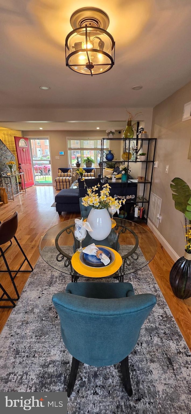 living area with healthy amount of natural light, baseboards, and wood finished floors
