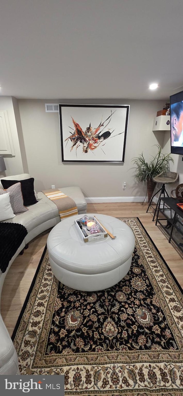 living room with light wood-style flooring, baseboards, and recessed lighting