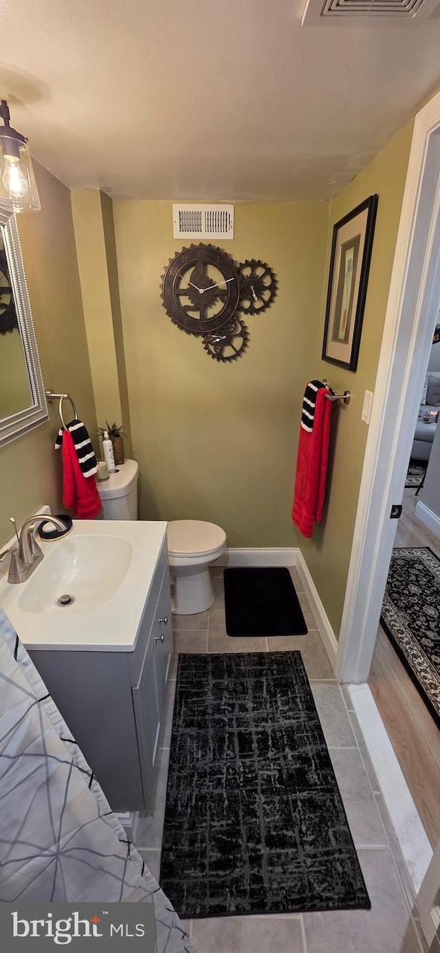 bathroom featuring toilet, vanity, and tile patterned floors