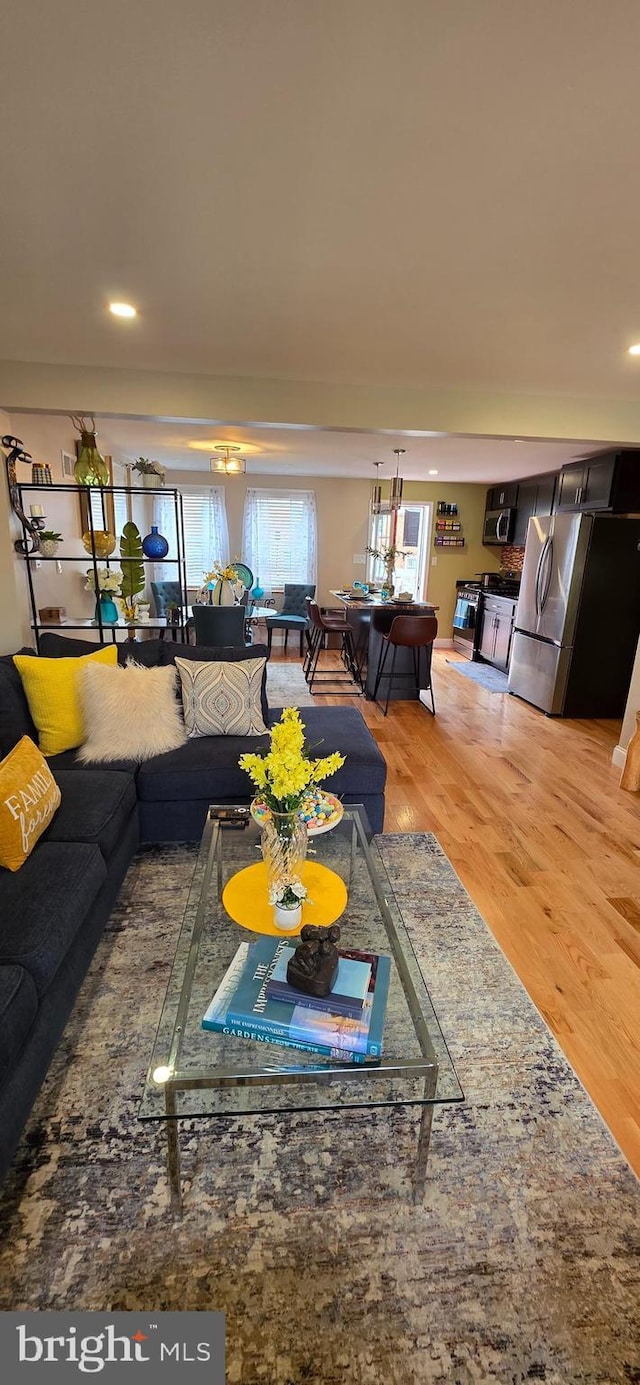 living area featuring light wood finished floors and recessed lighting