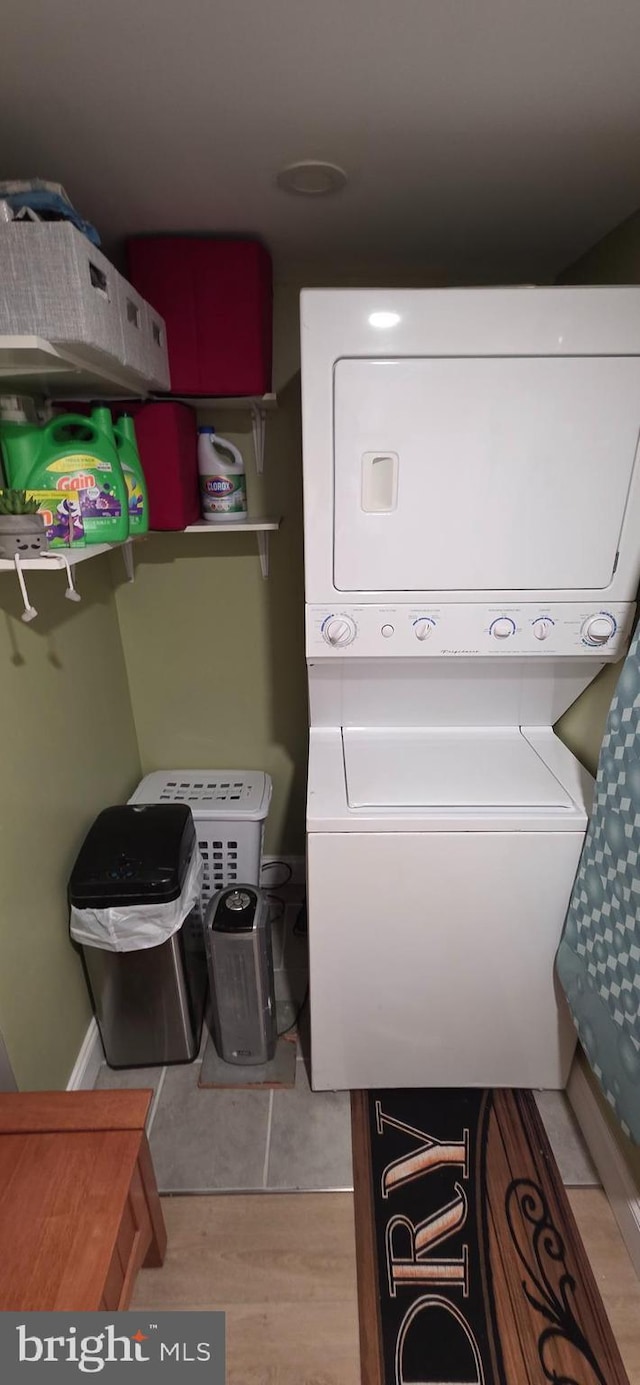 clothes washing area with estacked washer and dryer