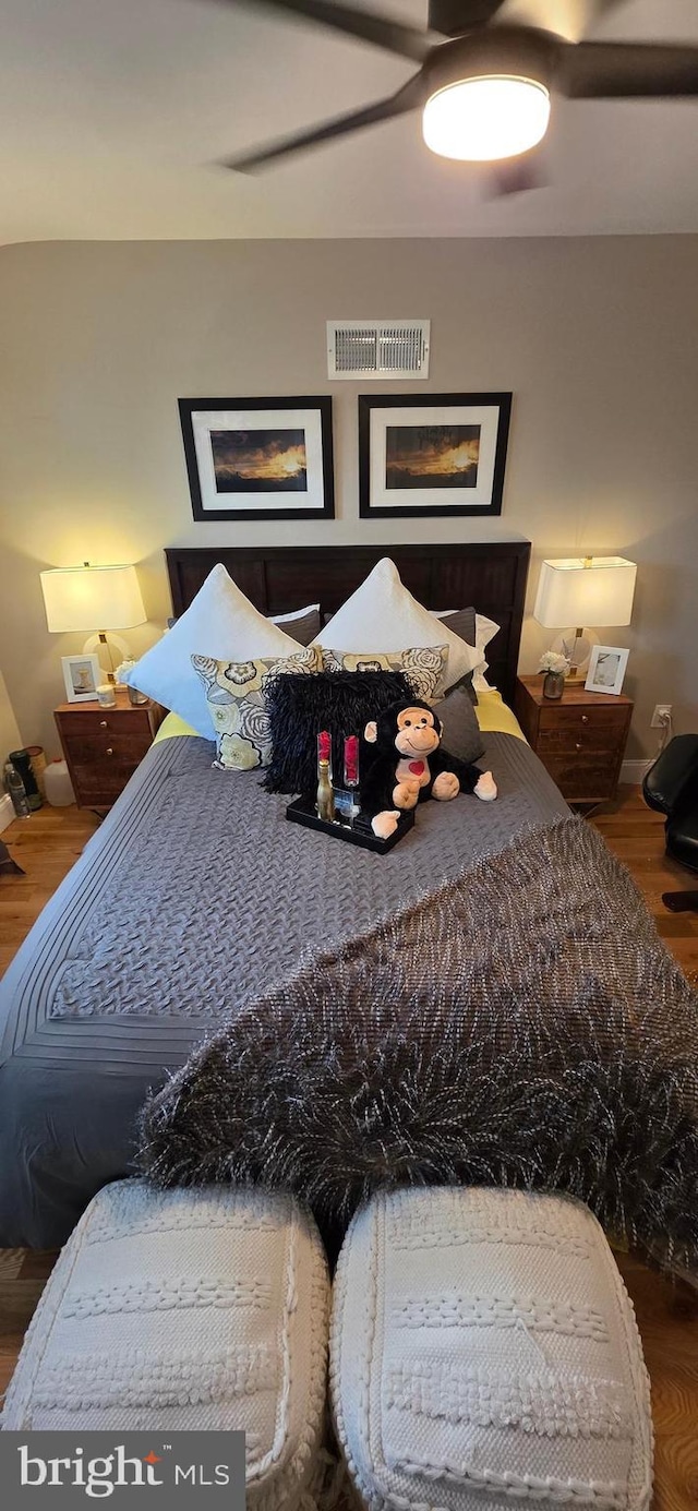 bedroom featuring ceiling fan, wood finished floors, and baseboards