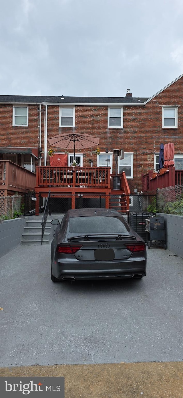 rear view of property featuring stairs and brick siding
