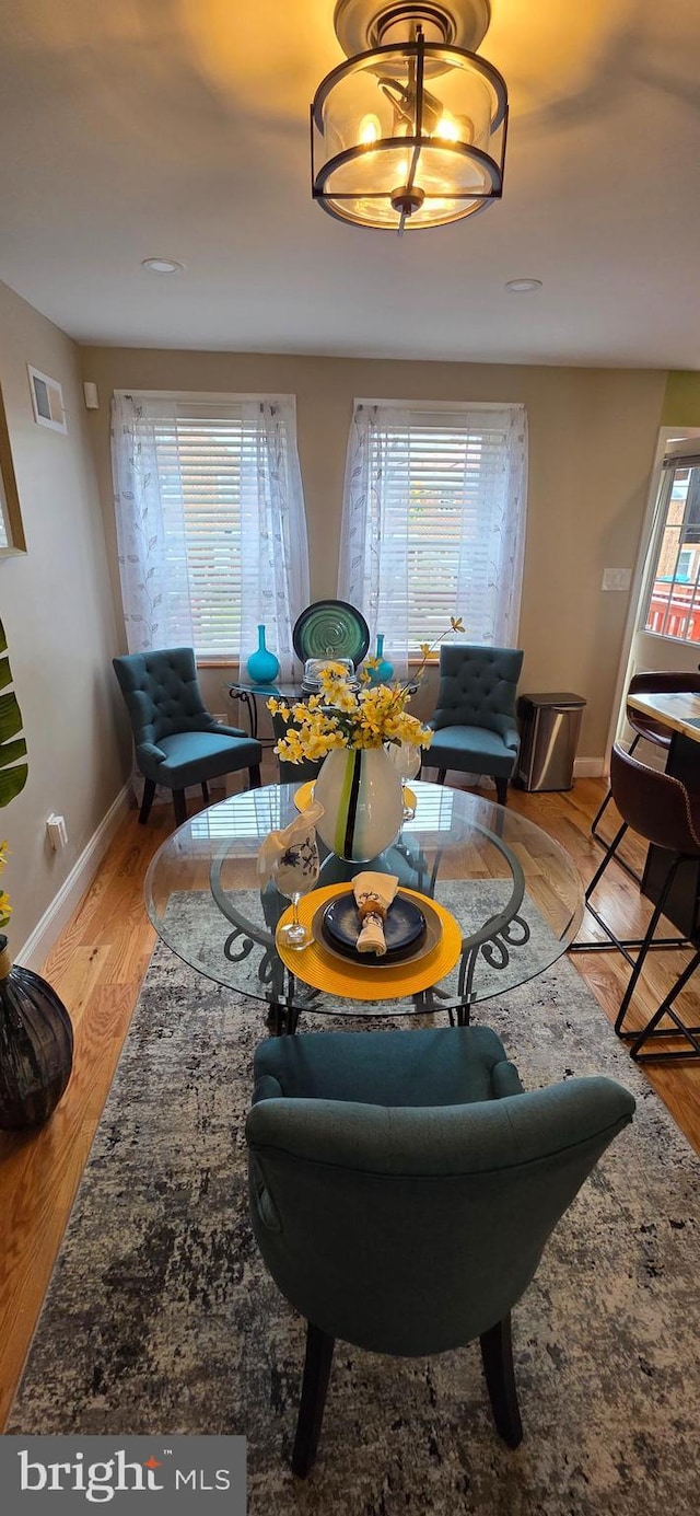 living area featuring plenty of natural light, baseboards, and light wood-type flooring