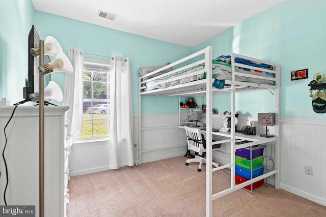 bedroom featuring a wainscoted wall, carpet flooring, and an office area